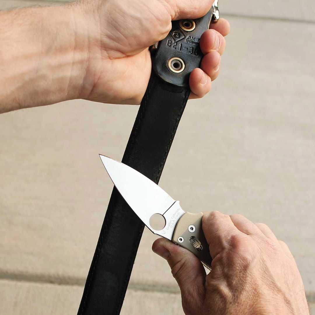 A hand holding a knife near a sheath.