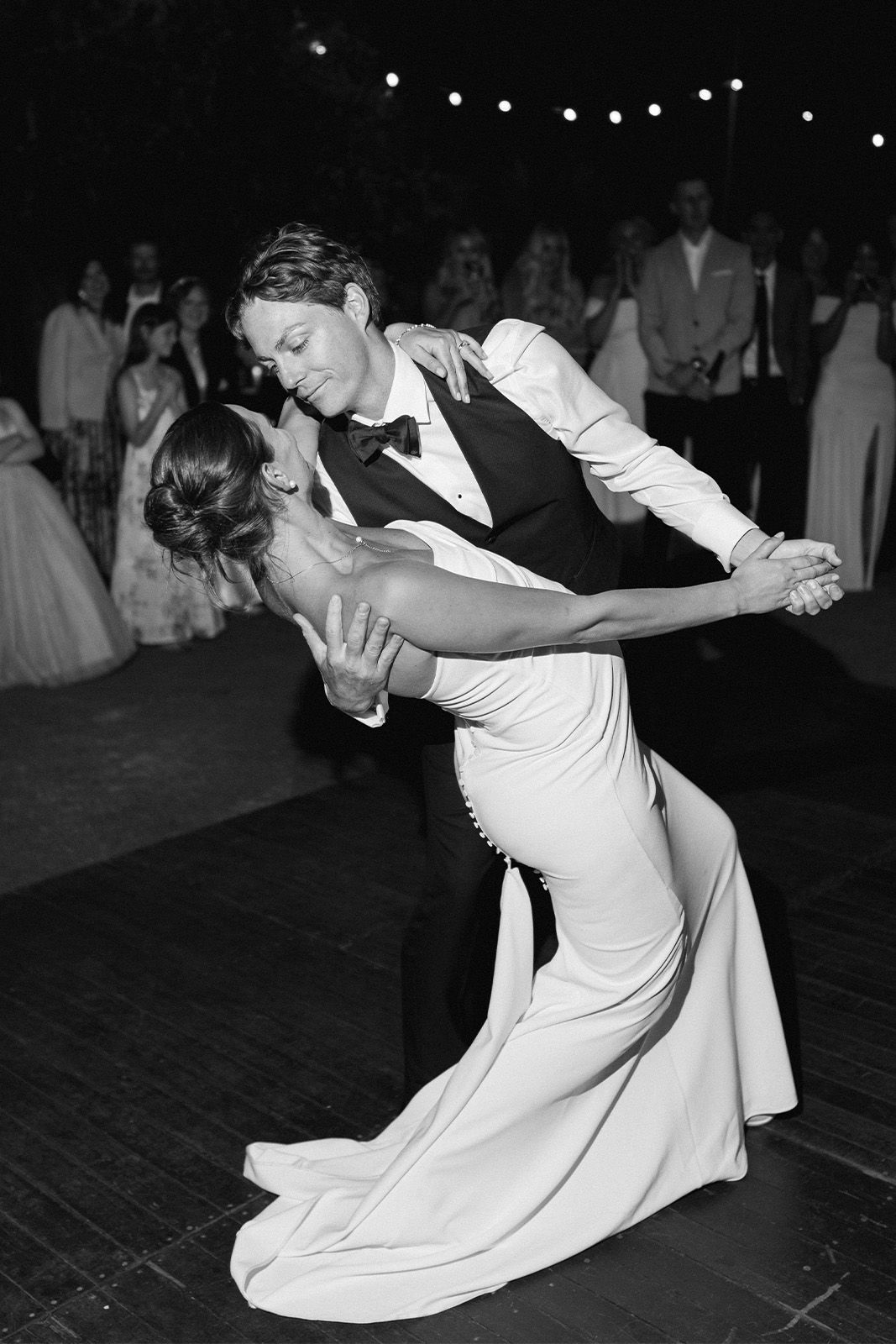 Couple dancing romantically at a wedding reception in black and white.