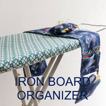An organizer for ironing tools hanging from an ironing board