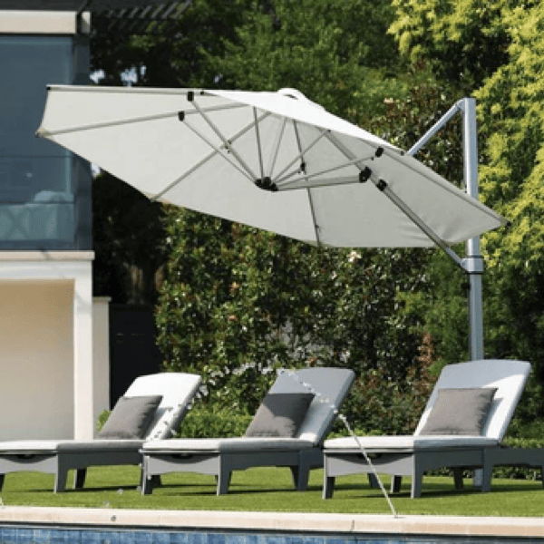 Poolside chaise lounges with a marine-grade stainless steel modern cantilever umbrella, showing durable outdoor furniture for sun-exposed spaces.