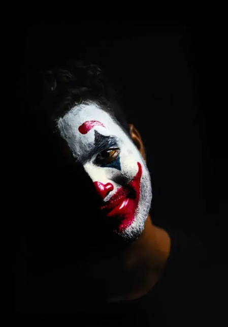 Image of man with face painted white like a clown.