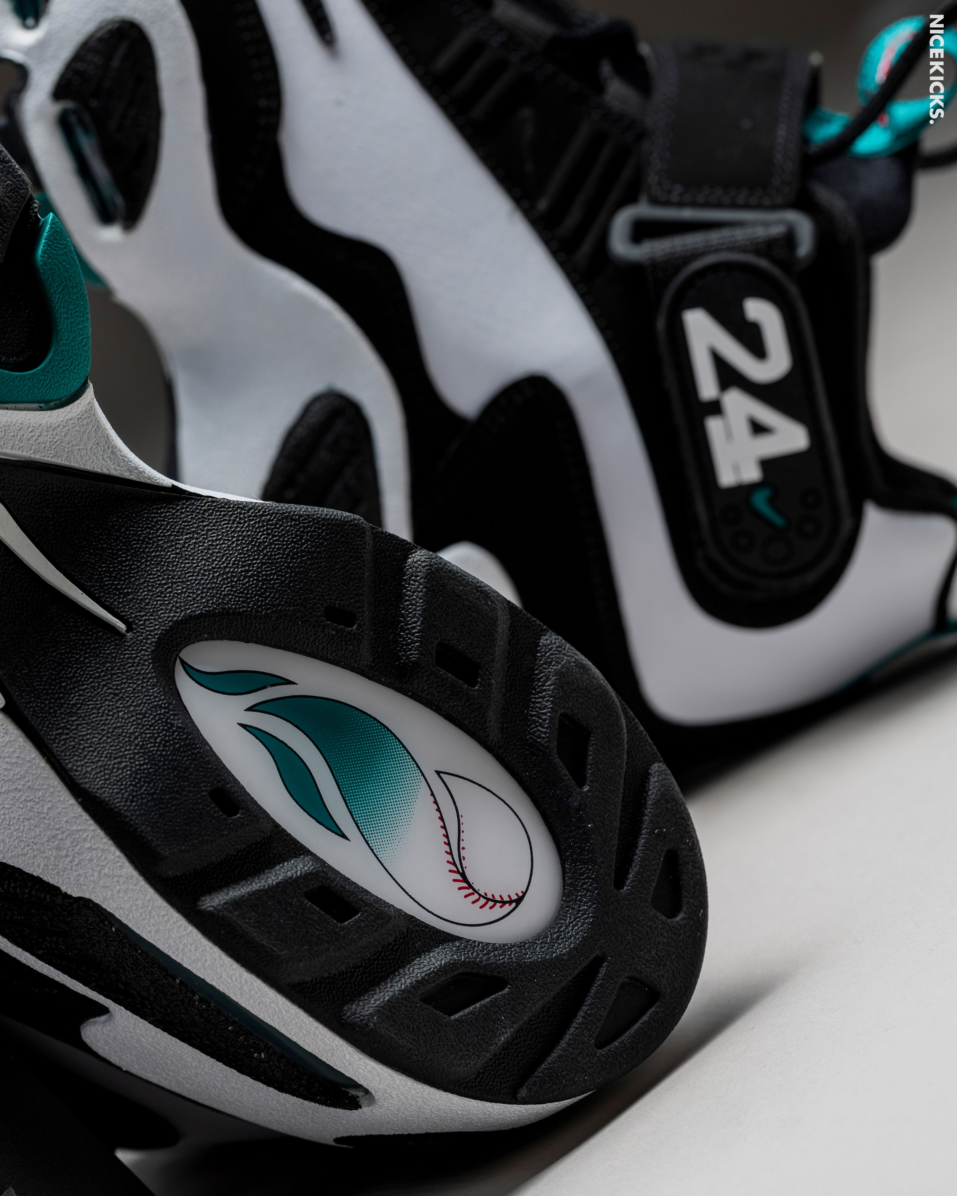A close-up of stylish black and white athletic shoes with teal accents.