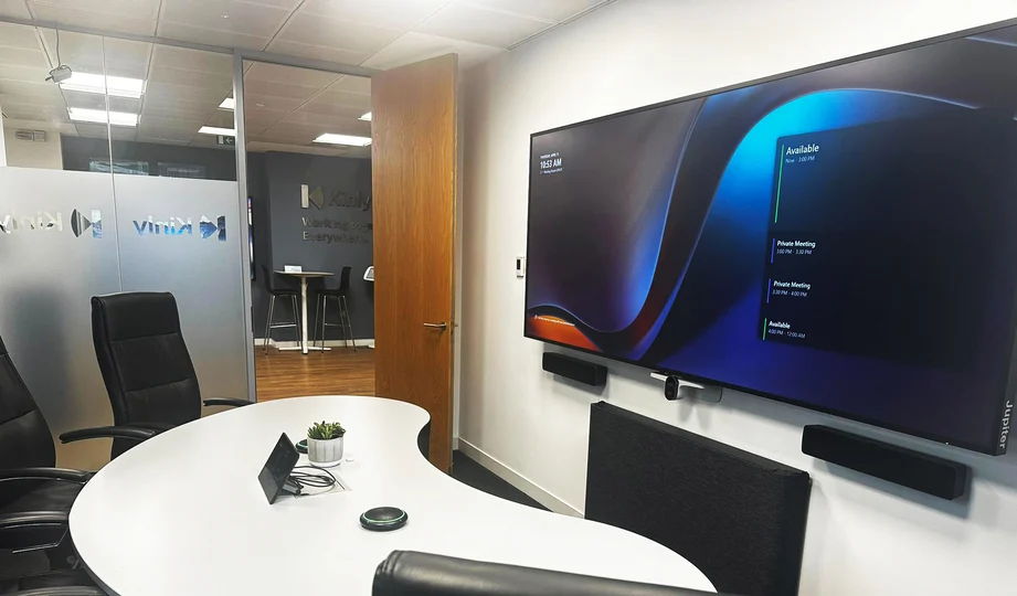 Modern conference room with a large screen and sleek furniture.