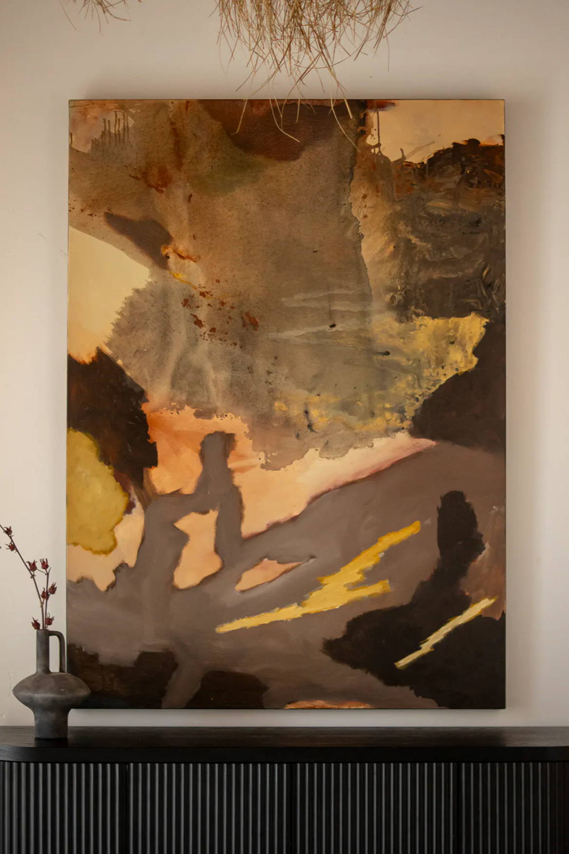 Abstract painting 'Undertow' from Stephen Skinner on wall above a dark wooden cabinet with decorative vase.