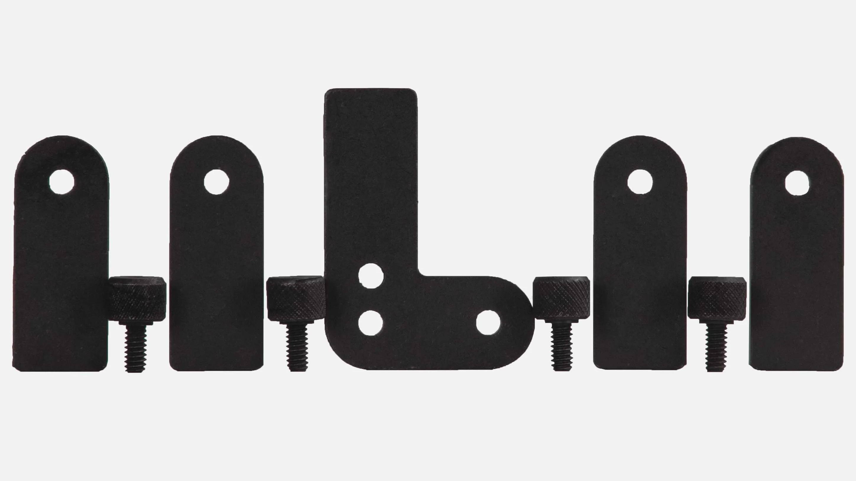 Various black metal brackets arranged in a row on a light background.