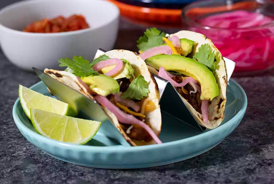 Plant-based meat tacos with avocado and lime on a dish