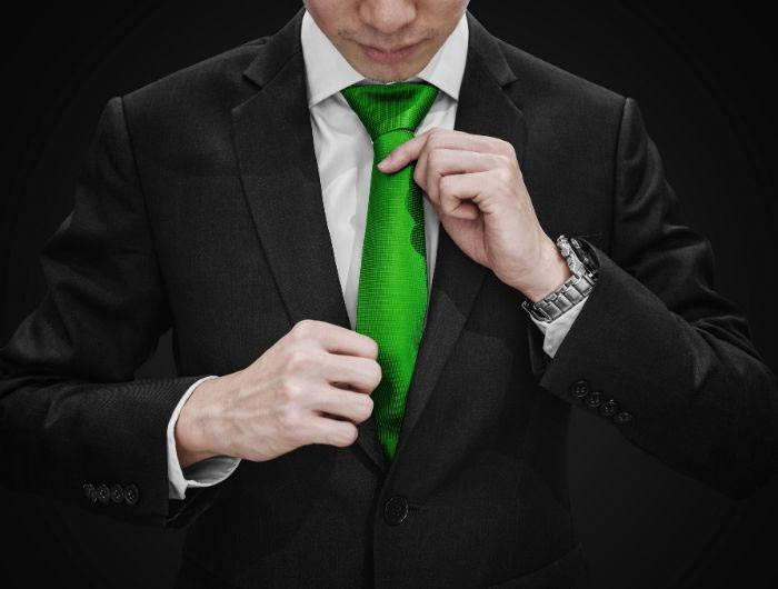 Man adjusting a green necktie