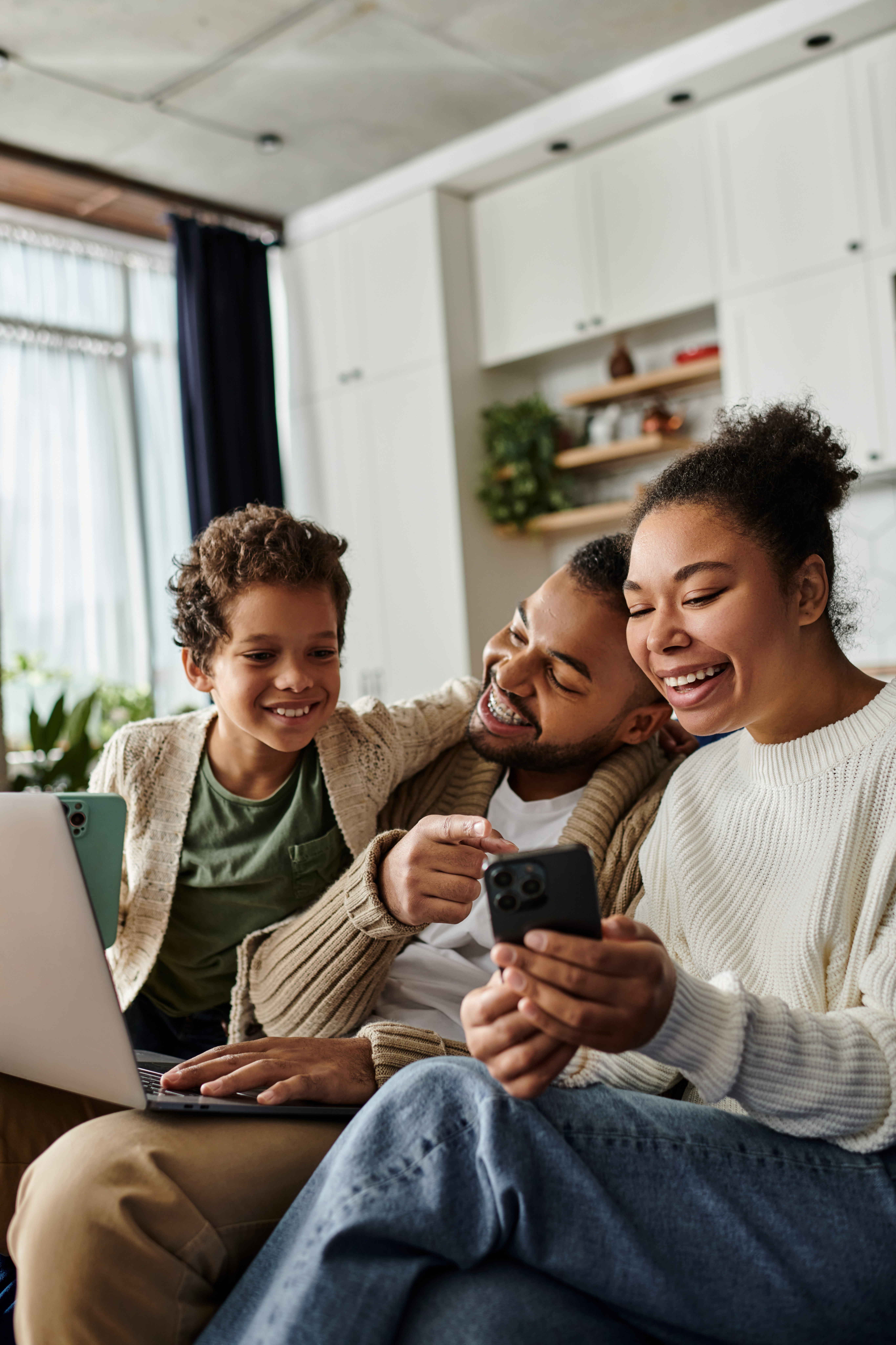 A family in the U.S. uses a smartphone and laptop powered by Gen Mobile unlimited eSIM data to video call relatives in France.