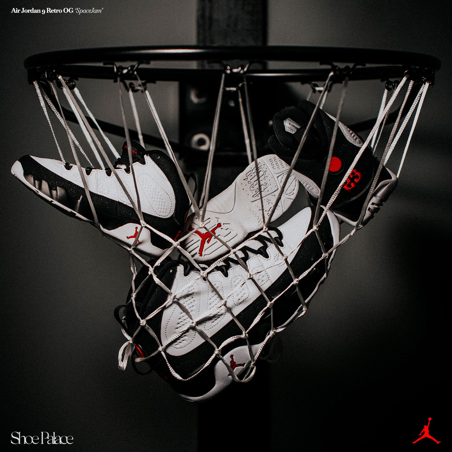 A pair of sneakers caught in a basketball hoop.
