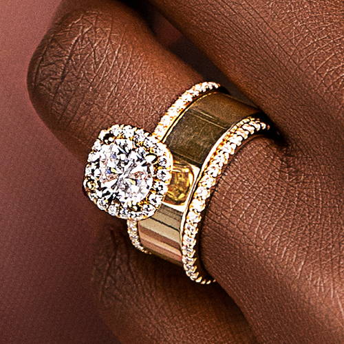 Woman wearing a halo engagement ring stacked with a plain metal cigar band and a skinny eternity lab grown diamond band by MiaDonna